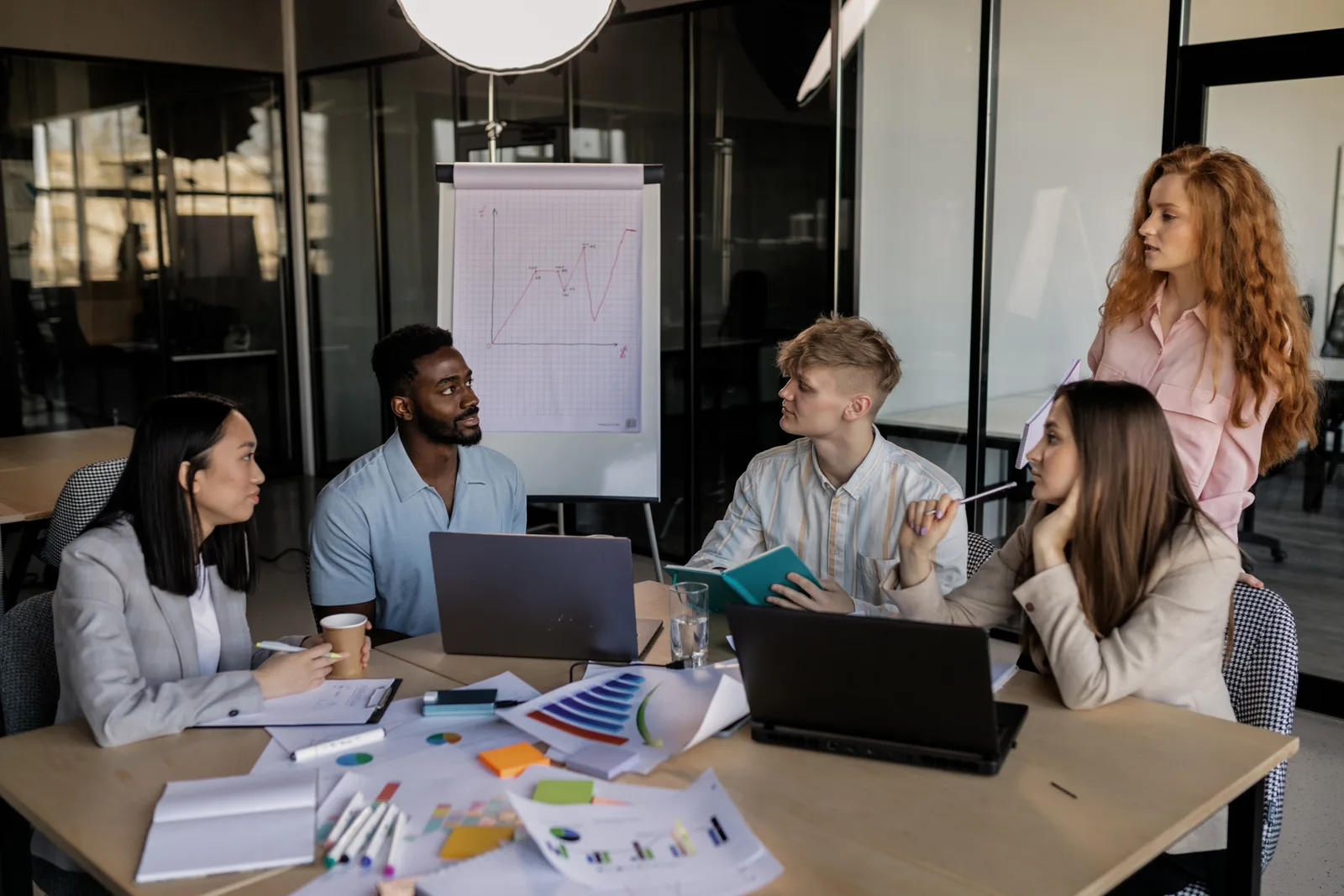 A marketing team reviewing growth charts and campaign data around a conference table
